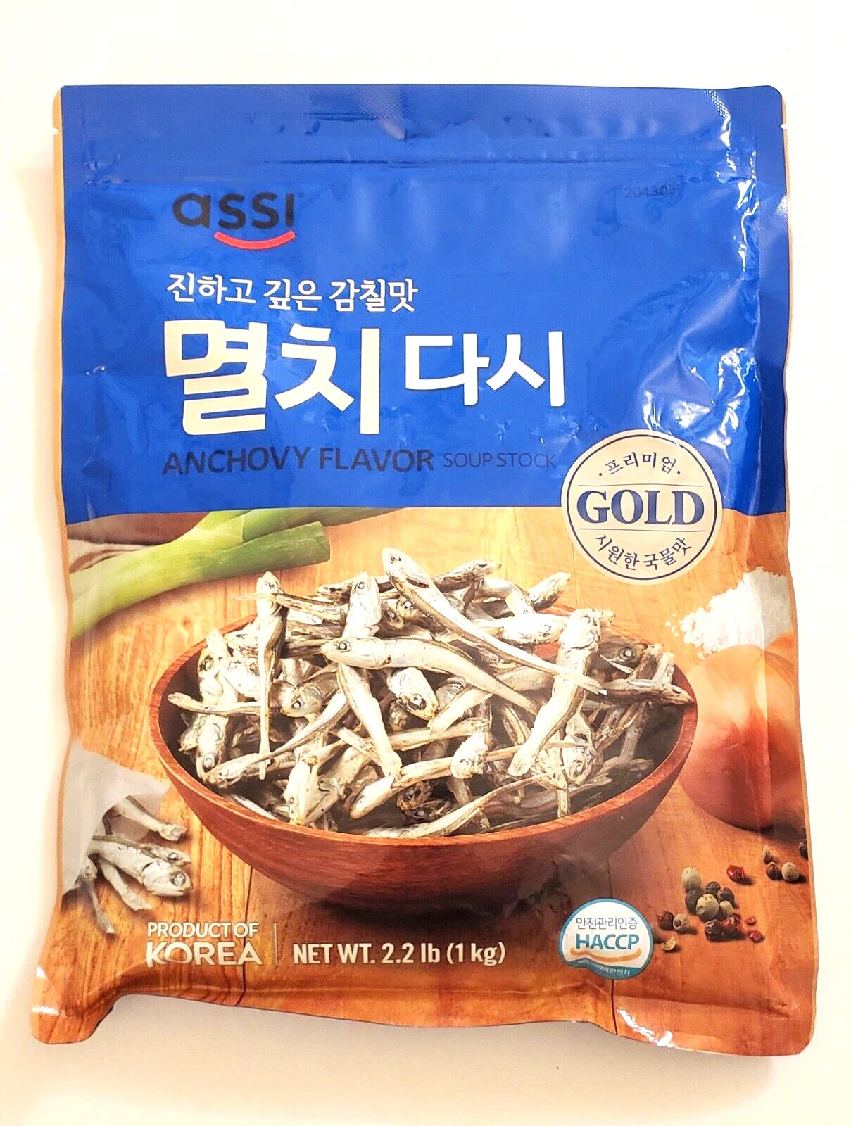 Assi anchovy flavor soup stock package with a bowl of dried anchovies on an orange background.