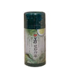 Bottle of matcha green tea powder on a textured beige background
