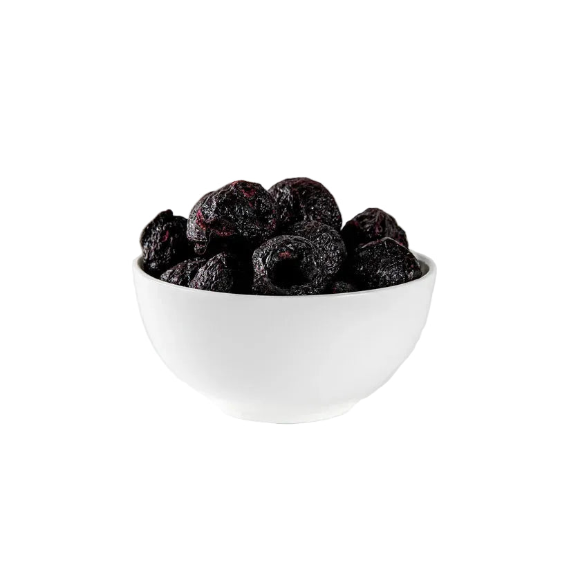 White bowl filled with dark berries on a white background