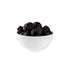 White bowl filled with dark berries on a white background