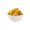 White bowl filled with yellow corn puffs on a white background